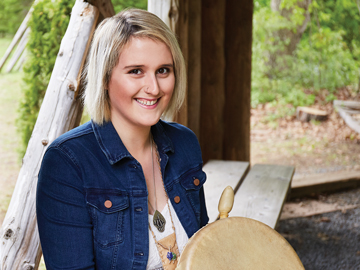 student holding ceremonial drum