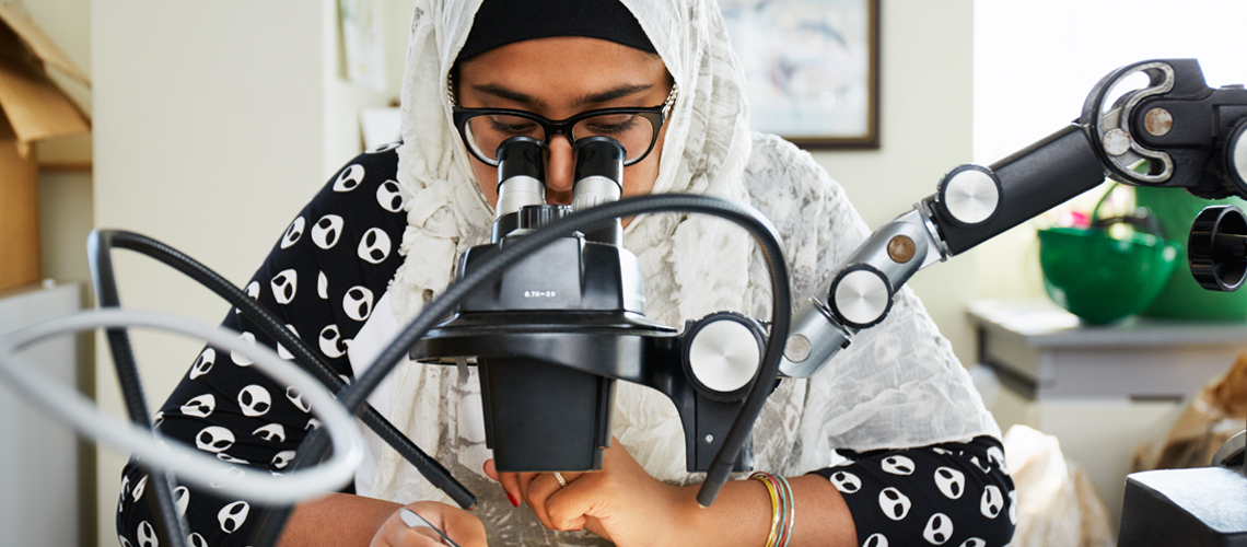 student looking through microscope