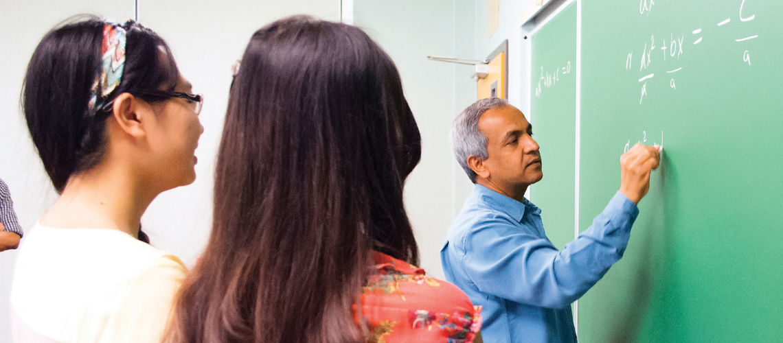 students watching professor at blackboard