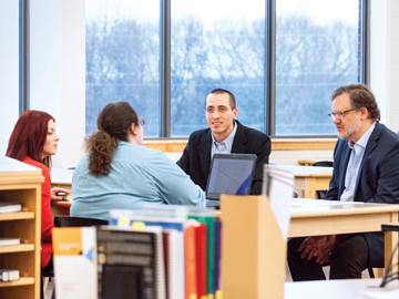 students and professors conversing in library