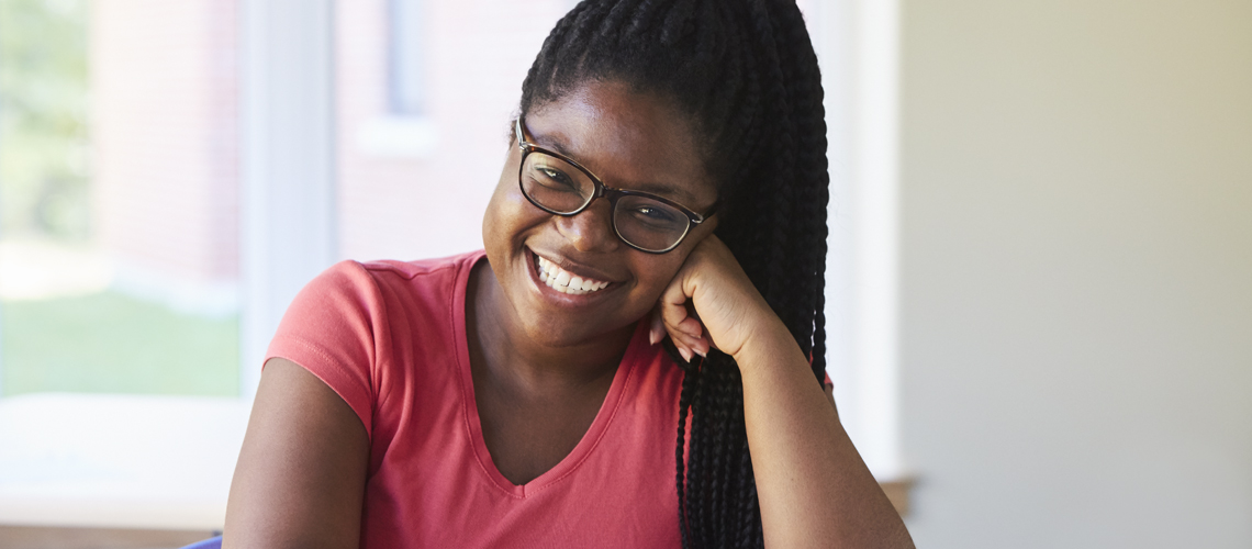 student smiling and leaning on left hand