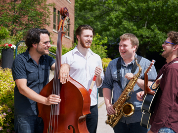 students standing in group holding instruments outside