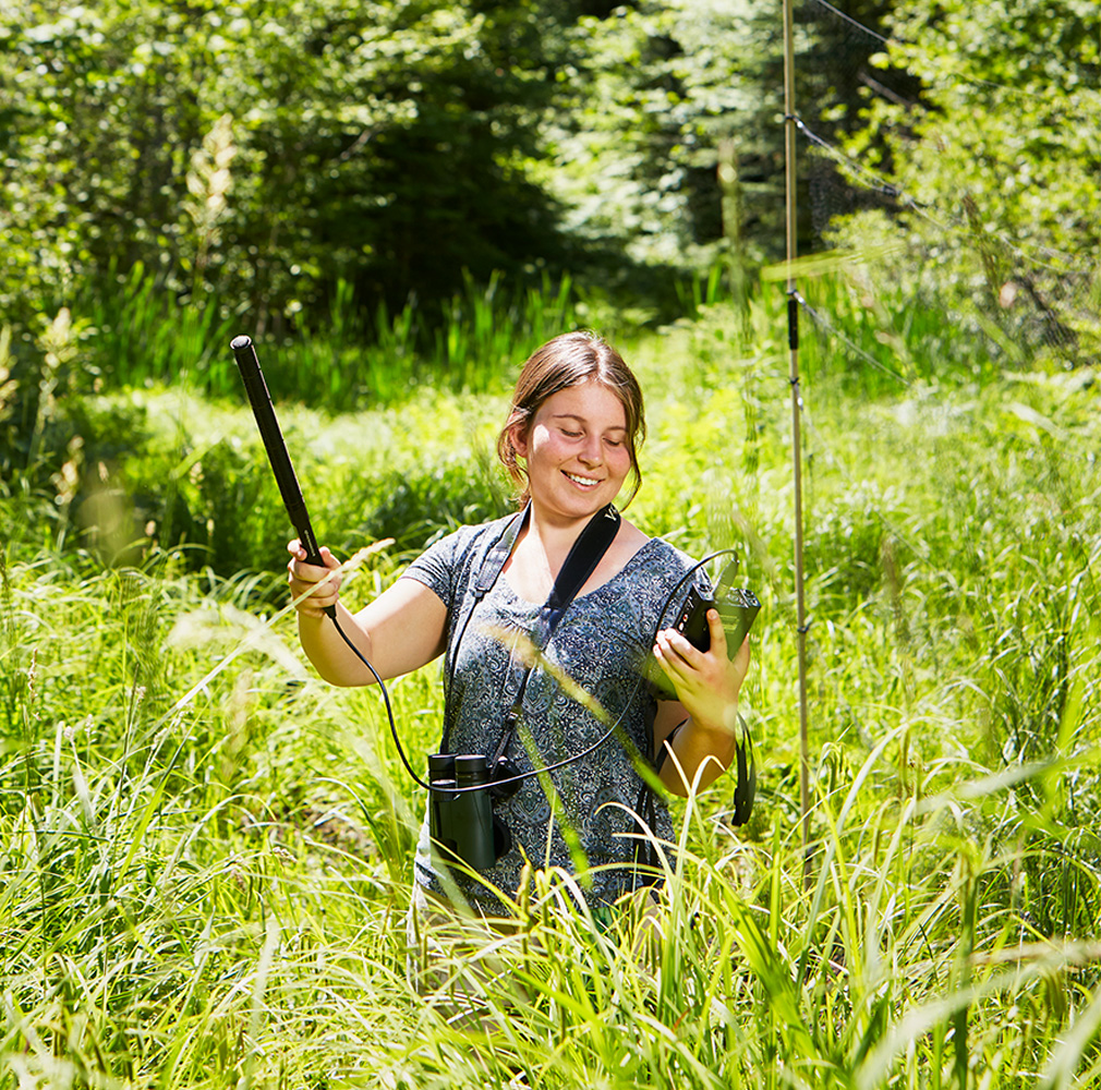 student taking readings in marsh