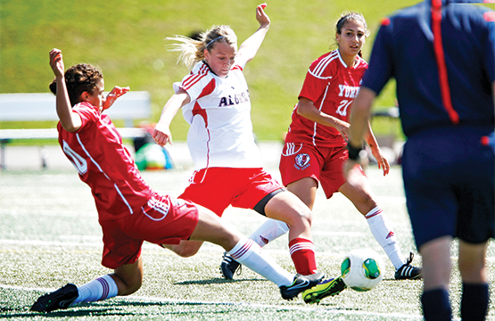 women's soccer team kicking soccer ball
