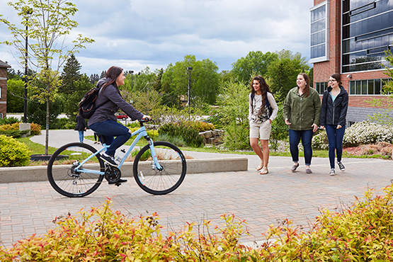 students walking and cycling through campus