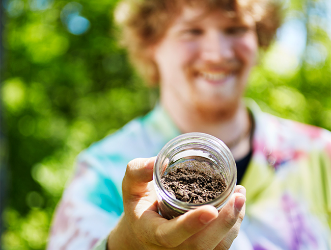 student holding jar of earth