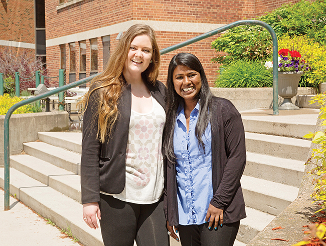 students smiling in front of steps