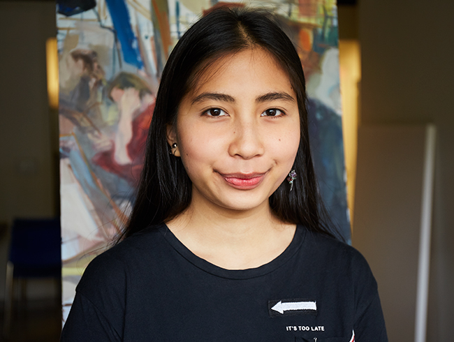 student in front of painting