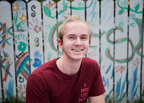 student with painted boards behind