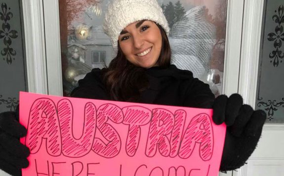 student holding austria here i come sign