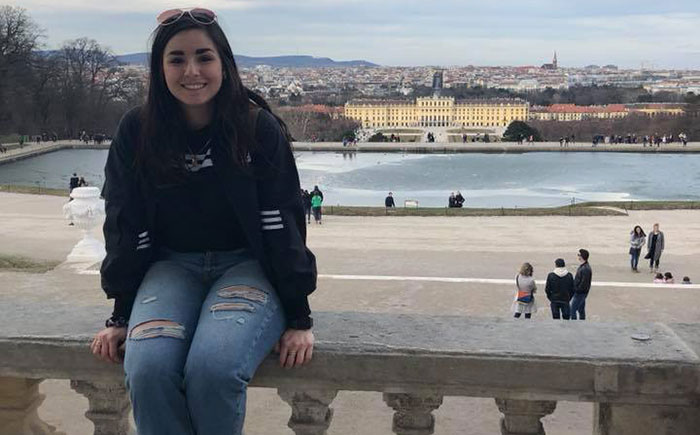 student posing in front of landscape