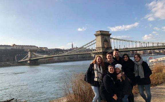students standing in front of bridge