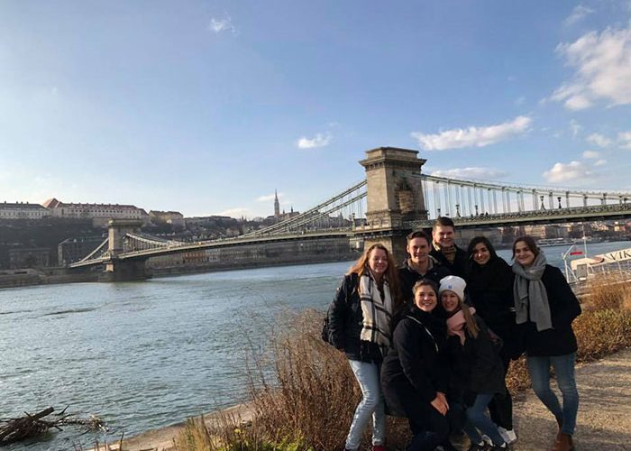 students standing in front of bridge