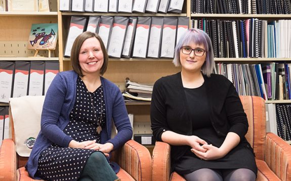 staff sitting and smiling in library