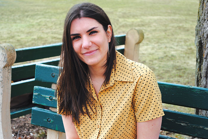 student smiling while sitting on bench