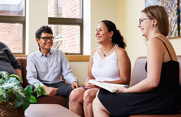 students sitting with faculty and discussing