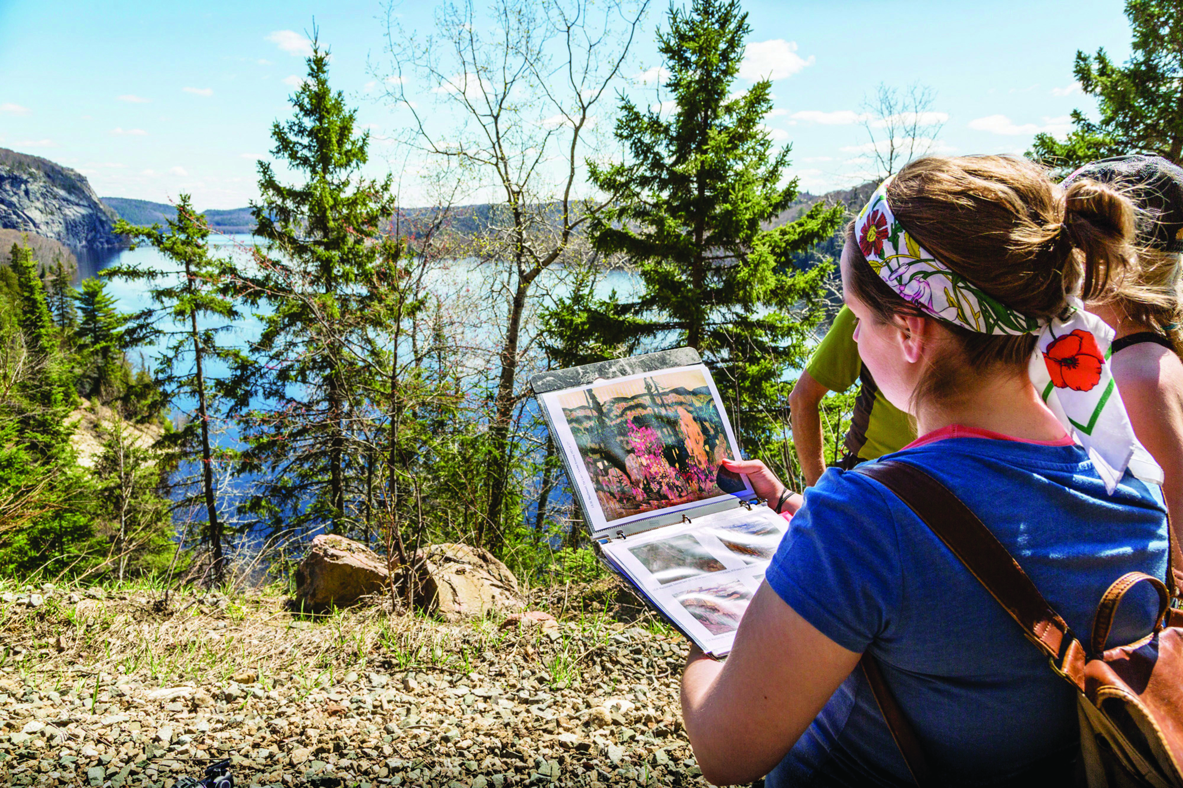 student outdoors looking at group of 7 painting overlooking Lake Superior