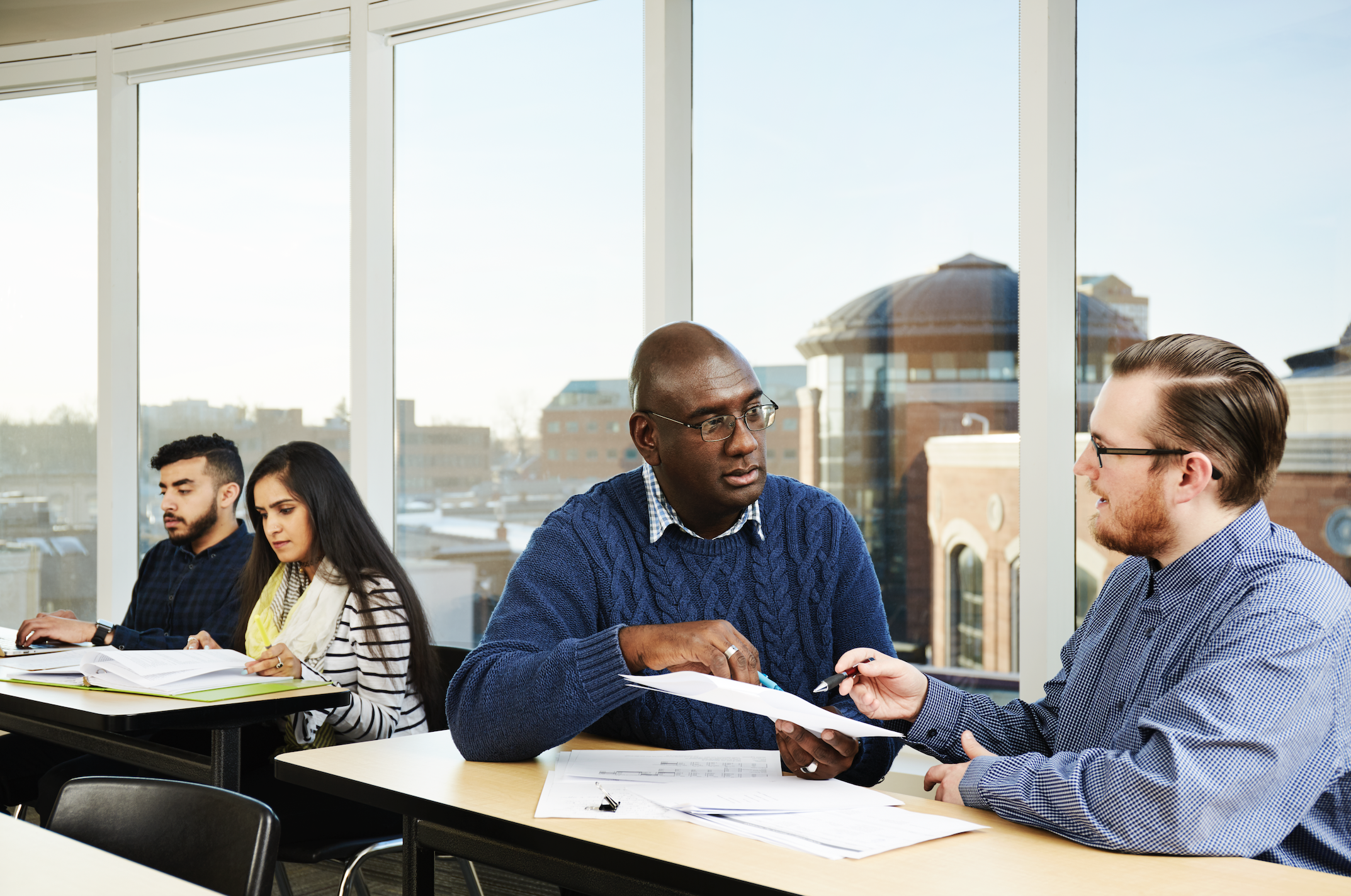 students in class discussing with faculty