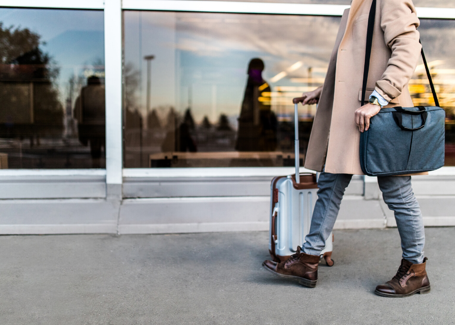 student walking with trolley bag and handbag