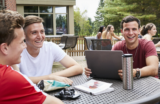 happy students sitting outside the class