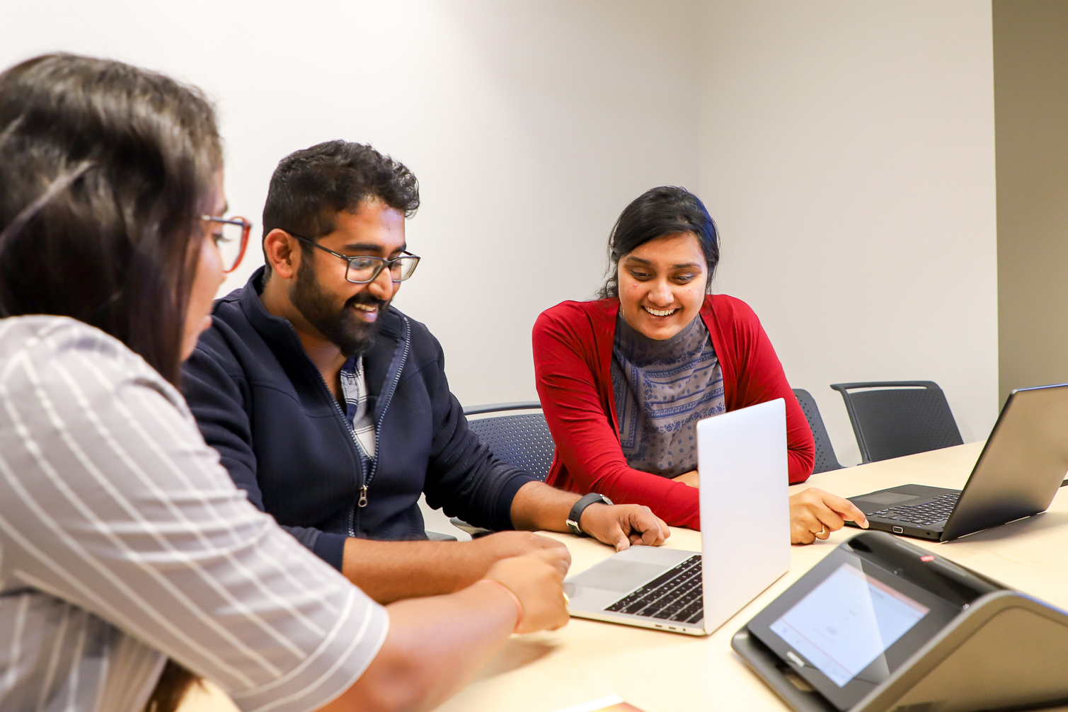 three students working together on their laptops