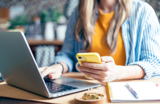 student on phone and laptop