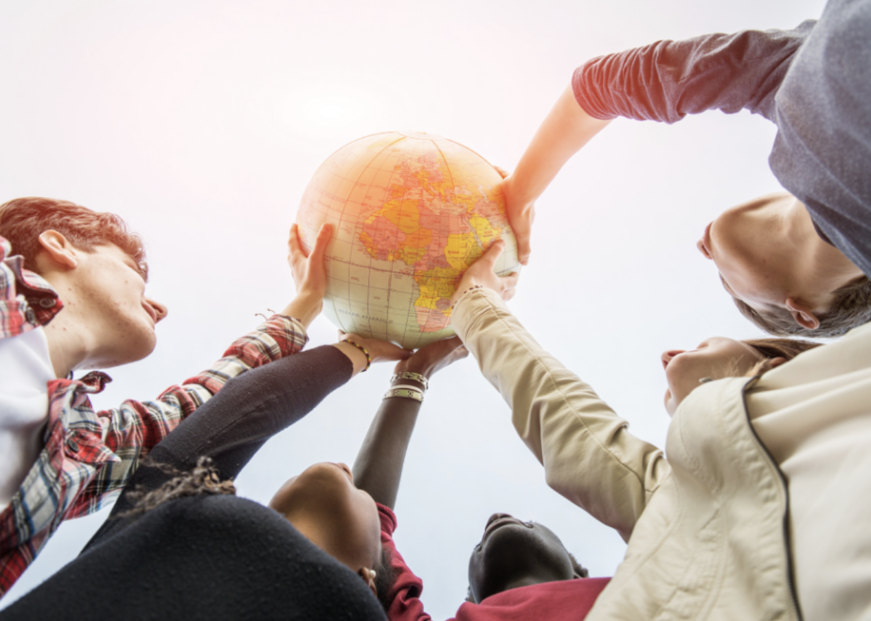 Students holding up globe together