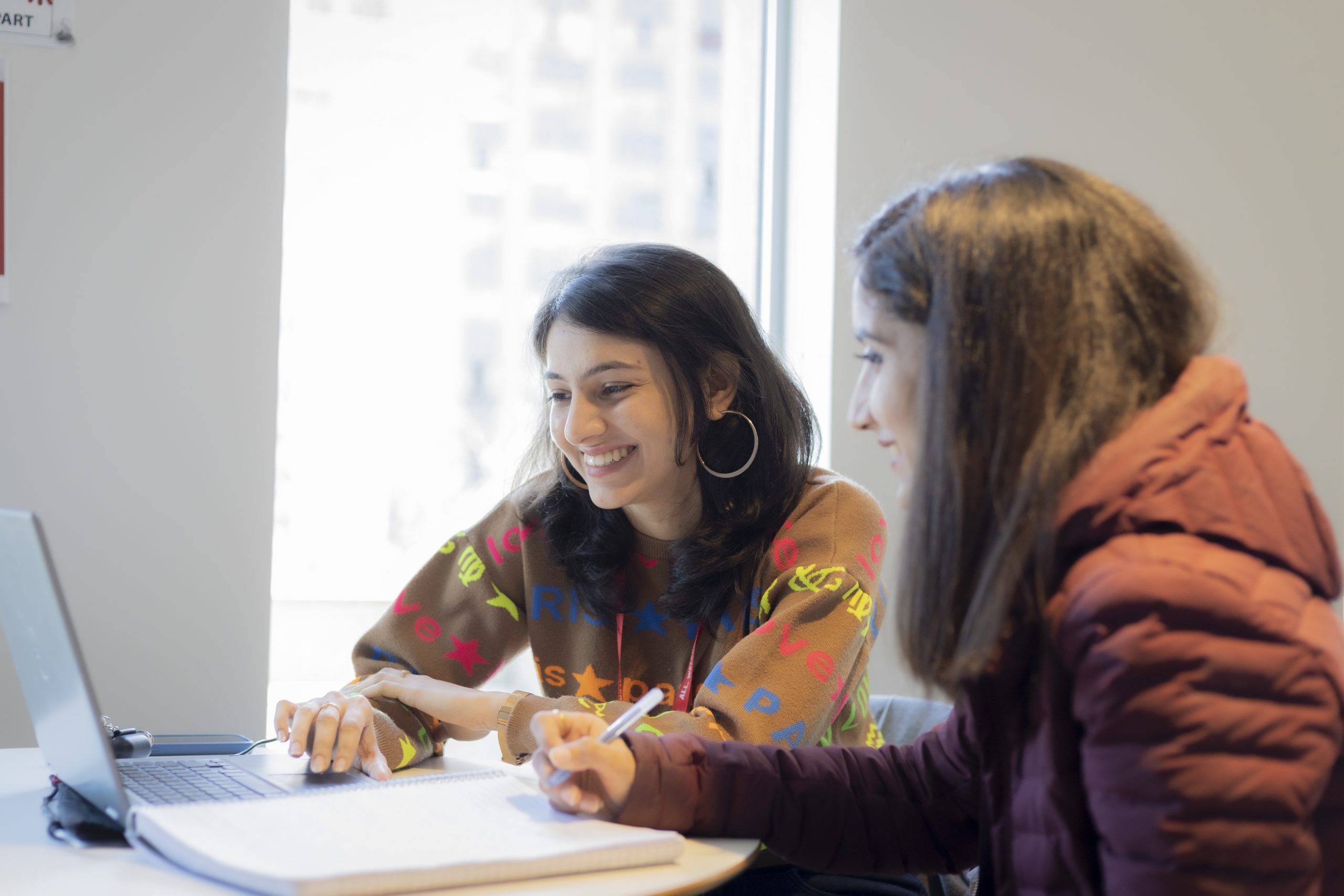 two students working on laptop