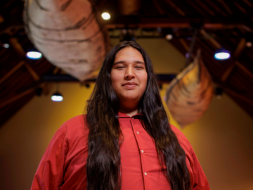 Student with canoes in background