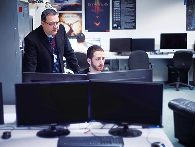 Faculty assisting student on computer