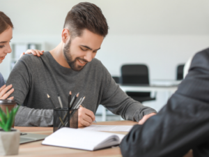 A person signing on lease papers